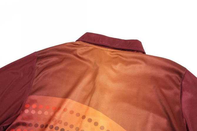 A maroon polo shirt featuring a gradient design and dotted patterns, with a collar and a branding logo.