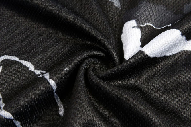 A close-up of a black fabric with a white abstract pattern, featuring a smooth, textured surface and branding.