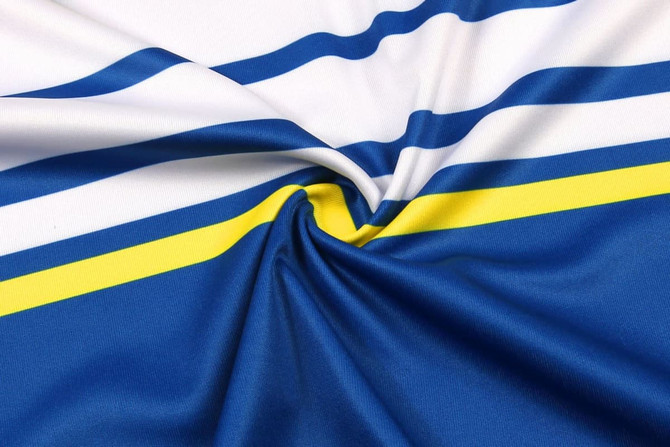 A close-up of interlock fabric featuring blue and white stripes with a yellow accent, showcasing its smooth texture.