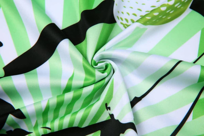 A patterned fabric in shades of green and black, featuring golf-themed designs and textures.