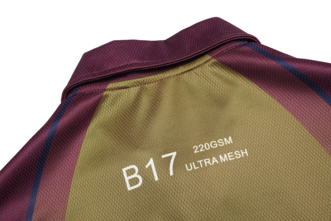 A collared polo shirt in burgundy and olive green, featuring a mesh design and a logo on the back.