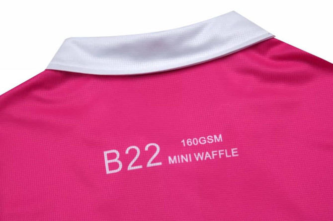 A pink women's polo shirt featuring a white collar and brand logo on the back.