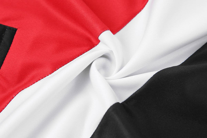 A fabric with red, white, and black sections, featuring a smooth, twirled texture. It has a logo visible on one segment.