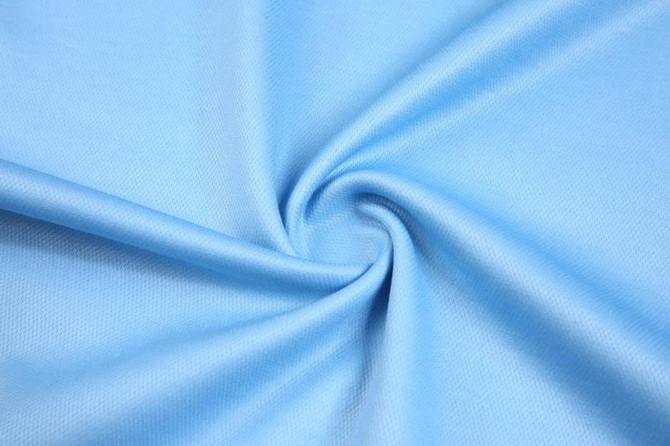 A light blue fabric with a smooth texture, showcasing a spiralled arrangement. It has a subtle sheen.