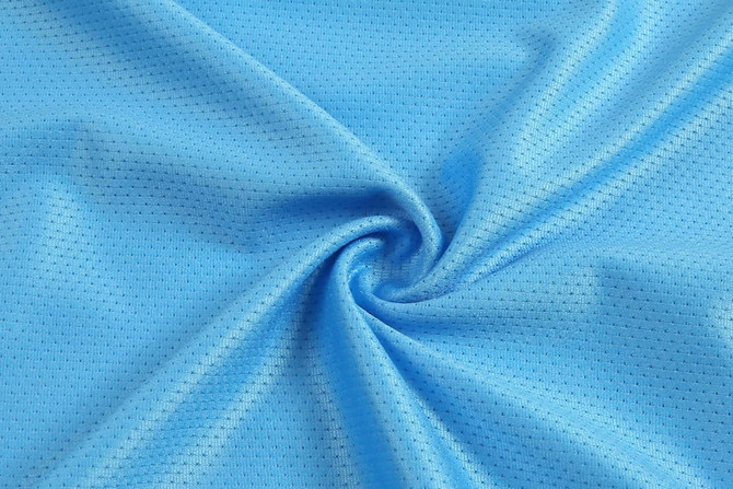 A light blue textured fabric in a swirling pattern, featuring a breathable mesh design.