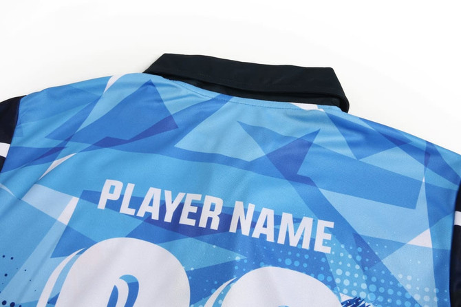 A cricket uniform top in shades of blue, featuring a collar and a logo on the back.