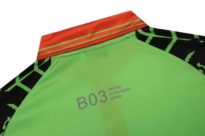 A green and black uniform featuring reflective tape at the collar, with an orange stripe and a logo.