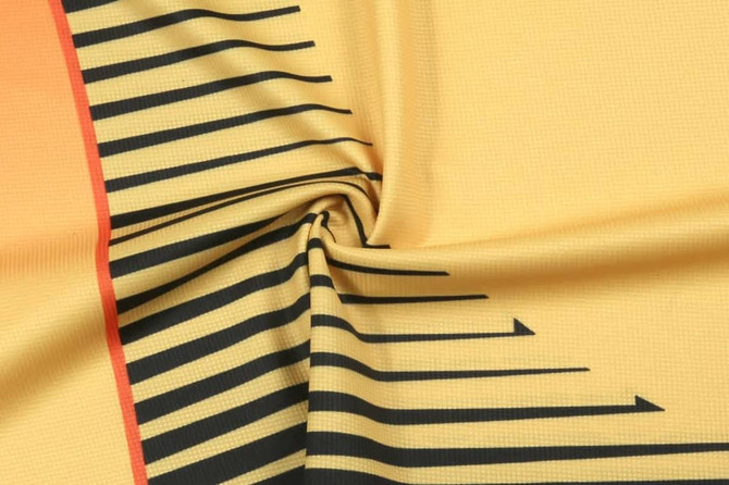 A textured fabric in yellow with black striped patterns, featuring an orange accent. Includes a logo design.
