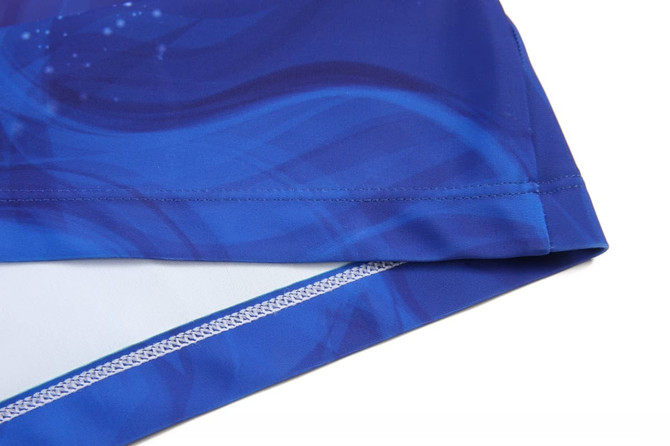 A women's running suit in shades of blue, featuring a smooth, flowing design and a logo.