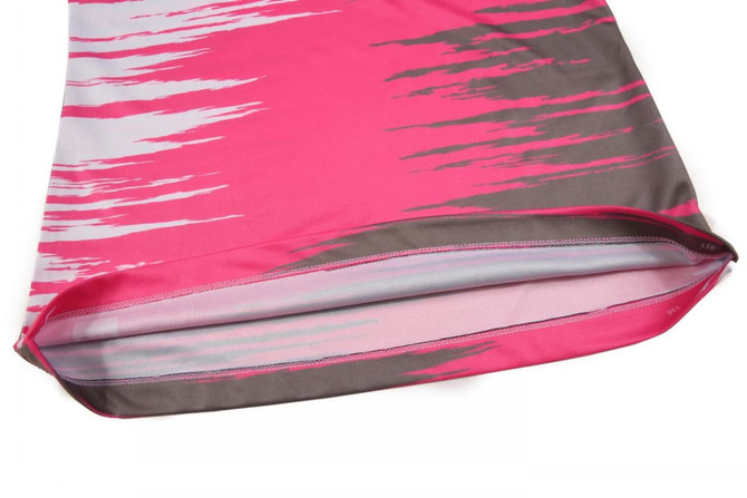 A pink racing singlet with a grey abstract pattern and a smooth finish at the hem. Features branding.