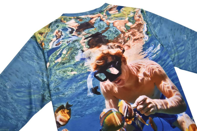 A holiday-themed T-shirt featuring a vibrant underwater scene with a person snorkelling among colourful fish.