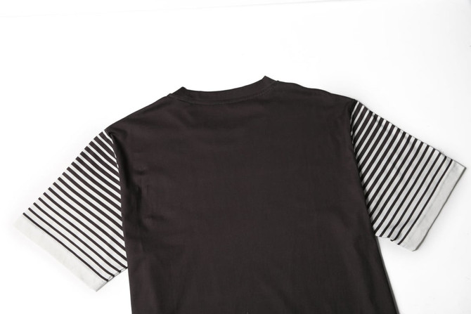 A black t-shirt with striped grey and white sleeves, featuring a logo on the back.