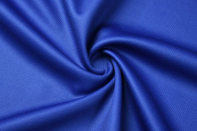 A close-up of a blue, textured fabric, showcasing a swirling pattern with a smooth finish.