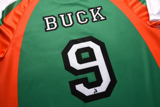 A green and orange sports jersey featuring the name "BUCK" and the number "9" on the back.