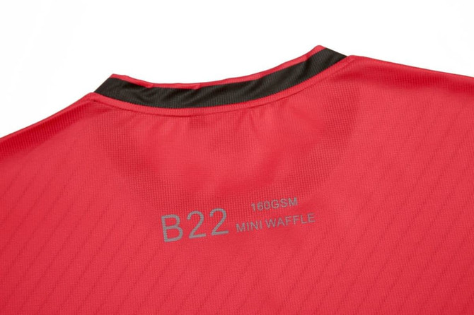 A red custom sportswear t-shirt featuring a textured pattern and a small logo at the back.