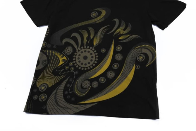 A black sublimation cotton tee featuring intricate yellow and grey abstract patterns on the front.