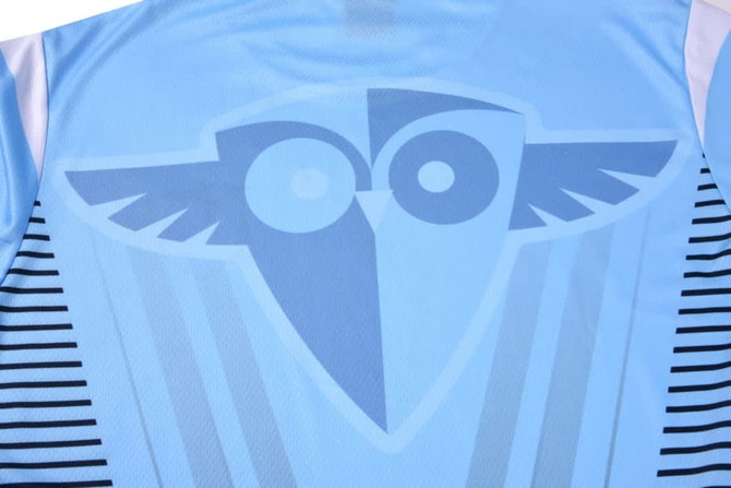 A blue sublimation round neck tee featuring a central logo and striped detailing on the sides.