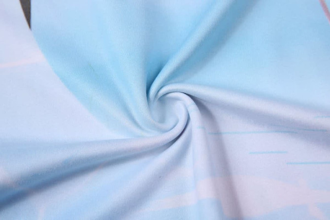 A light blue fabric with a soft texture, featuring a swirling pattern. The material is suitable for t-shirt production.