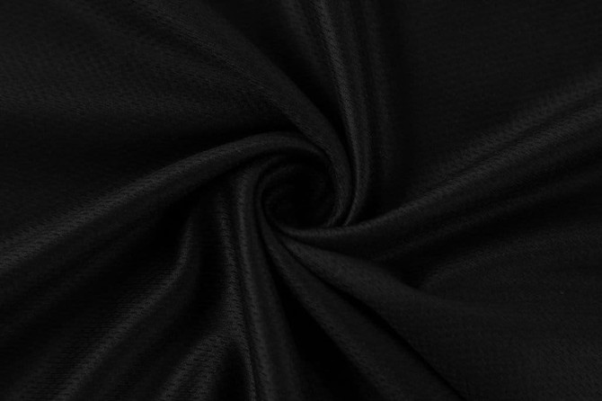 A black fabric material in a swirling pattern, showcasing its texture and smooth surface.