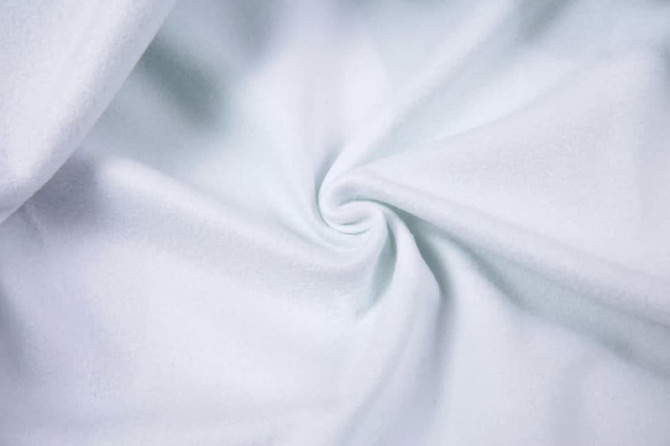 A light blue fabric with a smooth texture, twisted to showcase its softness and fluidity.