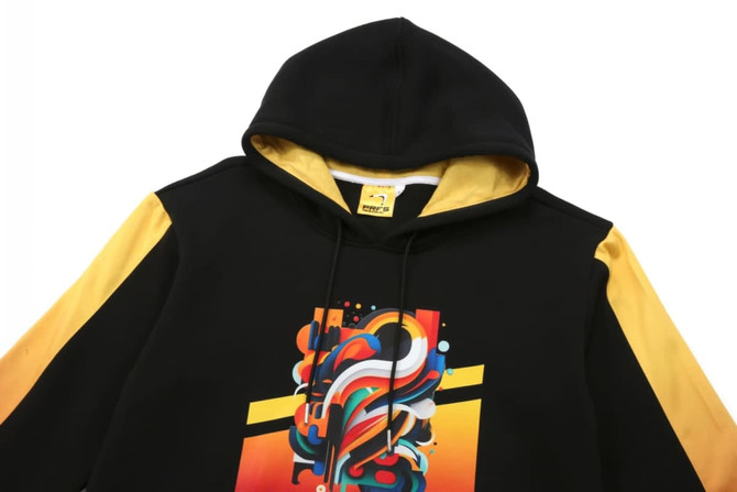 A black and yellow hoodie featuring a colourful abstract graphic on the front and a hood. It has a logo.
