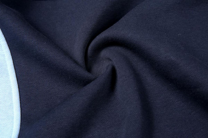 A close-up of navy blue polar fleece fabric, showcasing its soft texture and smooth finish.