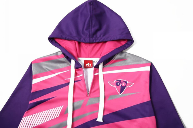 A purple and pink 1/4 zip hoodie with a hood and a logo on the chest, featuring geometric designs.