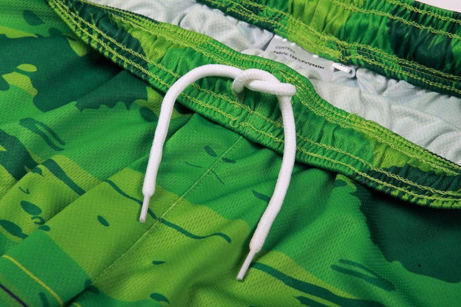 A pair of green shorts featuring a textured design and a white drawstring adjustment.
