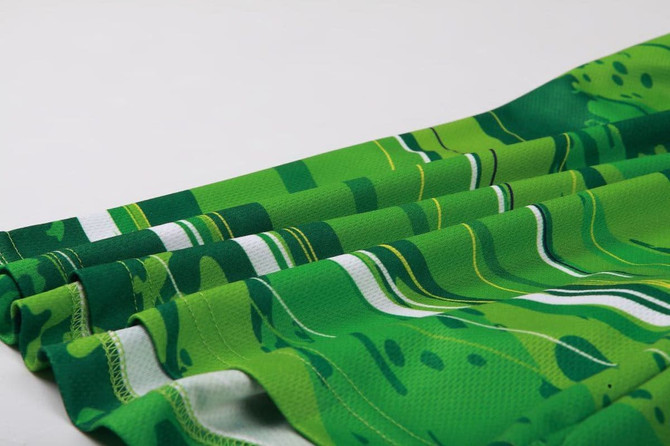 A pair of green patterned shorts with horizontal stripes and a soft fabric drape. Features branding.