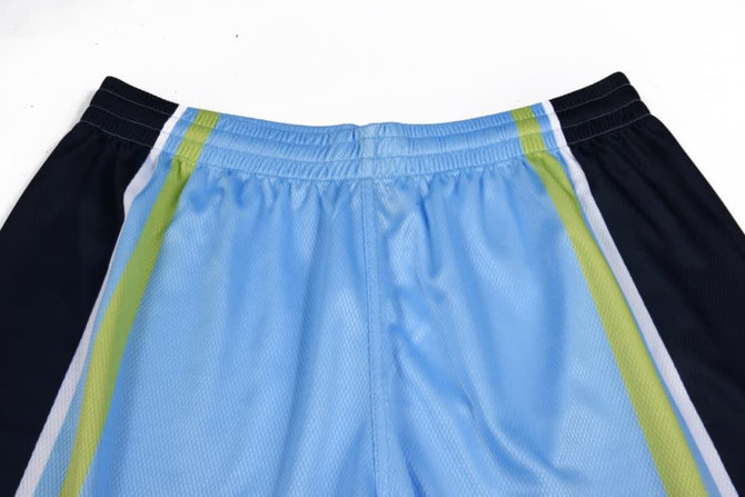 Light blue and black soccer shorts featuring green and white stripes, with an elastic waistband. Includes a logo.