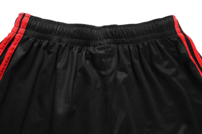 Black shorts with red side stripes and an elasticated waistband, featuring a logo on the waistband.