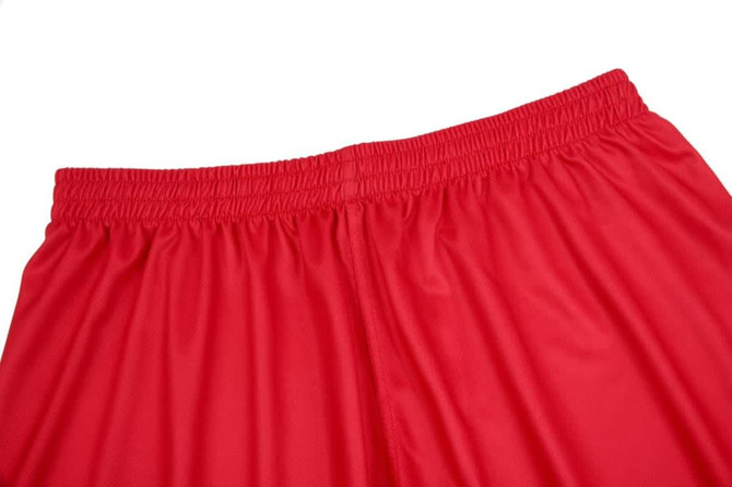 Red uniform shorts with an elastic waistband, featuring a smooth fabric texture. The image has a logo on the waistband.
