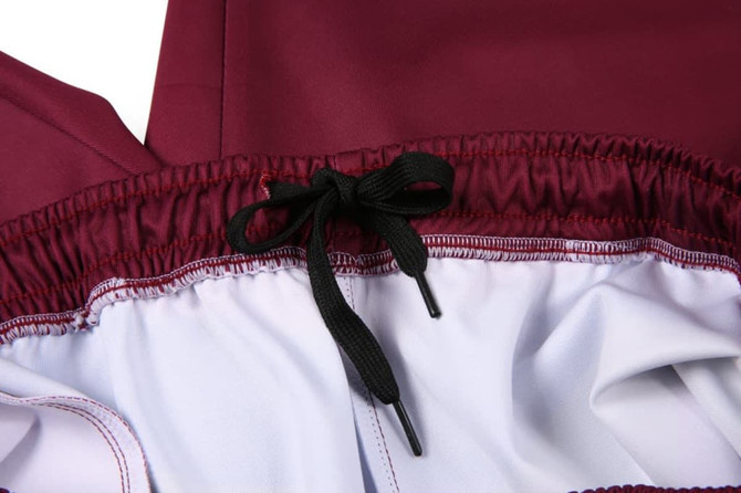 A pair of maroon training pants featuring a black drawstring and a contrasting white inner lining.
