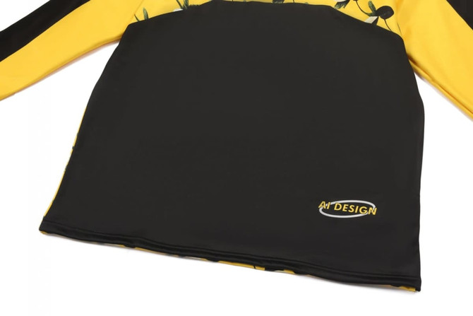 A black and yellow pullover jumper with floral designs and a logo on the bottom right.