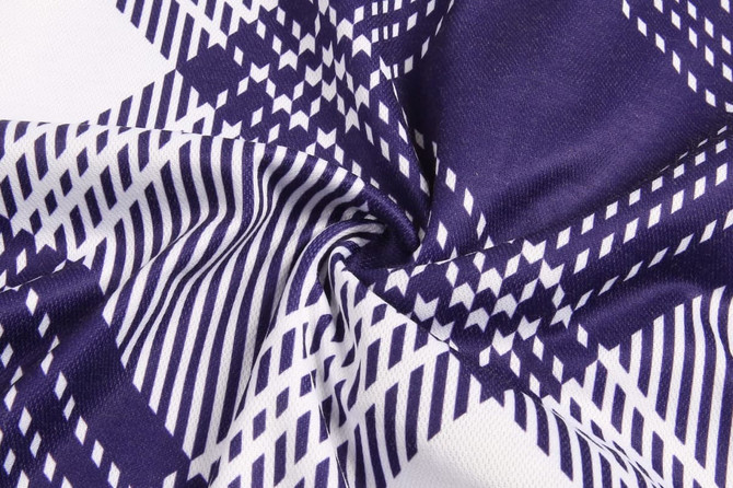 A close-up of fabric featuring a geometric pattern in navy and white. The material is soft and textured.