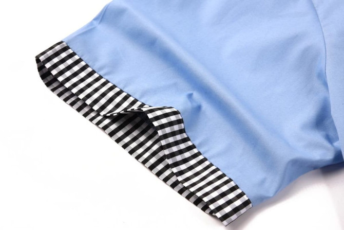 A blue school shirt with a checked black and white cuff detail. The shirt features a smooth fabric finish.