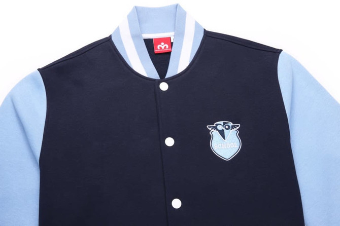 A collegiate jacket featuring navy and light blue colours, with a logo and contrasting striped collar.