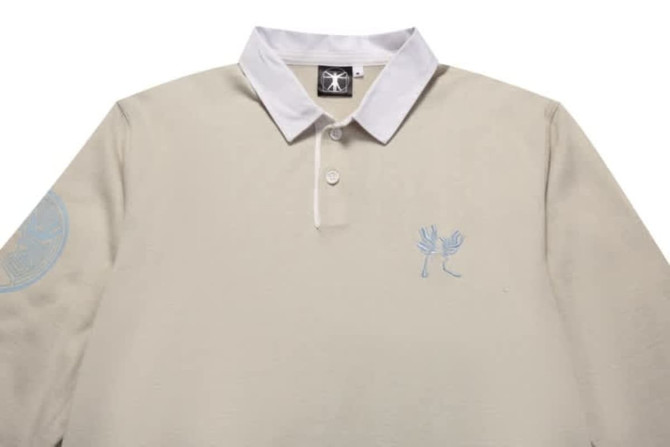 A beige sports jumper featuring a white collar and an embroidered design, complete with a logo on the sleeve.