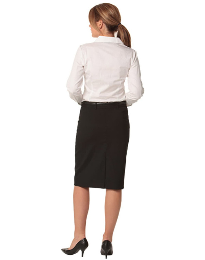 A women's black mid-length lined pencil skirt in wool stretch, worn with a white shirt and black heels.