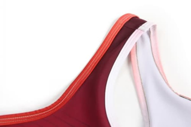 A maroon and pink sports uniform featuring a sleeveless design and contrasting trim. Includes a logo.