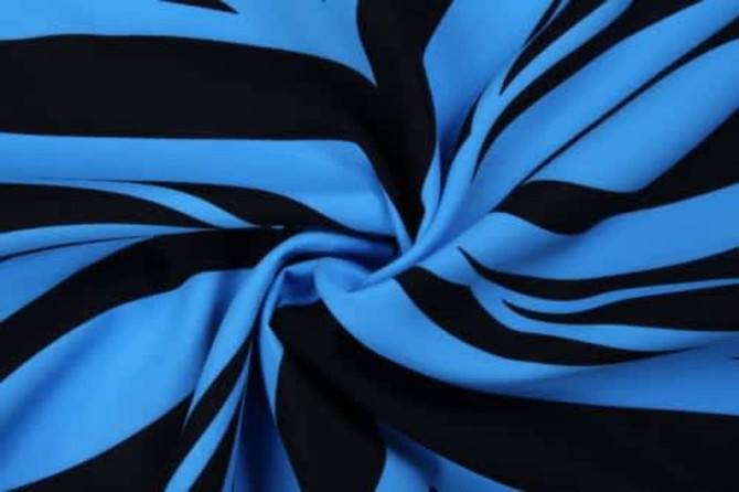 A swirl of fabric featuring bold blue and black stripes, showcasing a smooth, stretchy texture.