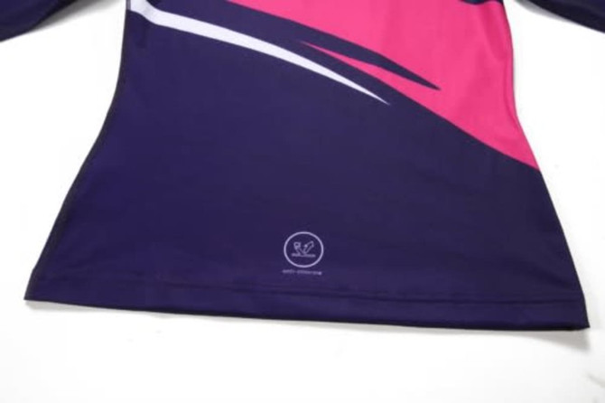 A swimming coat in dark purple and pink, featuring long sleeves and a logo at the bottom.