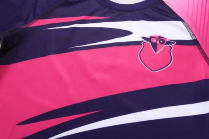 A sports uniform featuring a navy and pink colour scheme with a logo on the front.