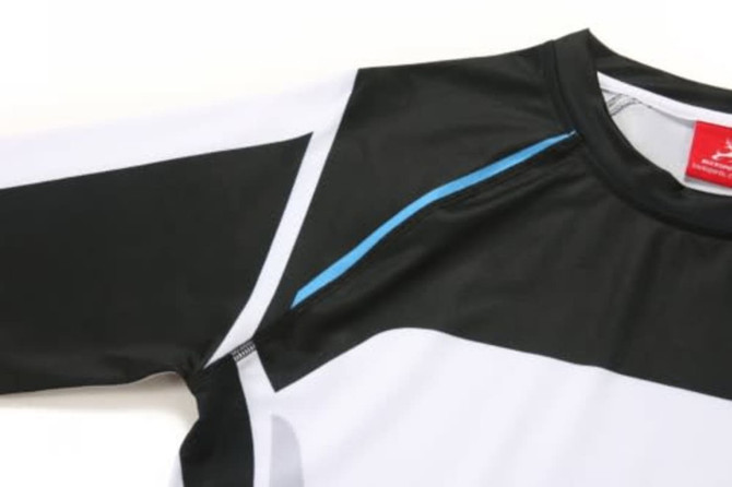 A sports uniform in black and white with blue accents, featuring a logo on the collar and long sleeves.