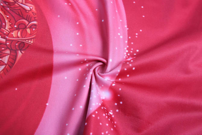 A swirl of pink fabric featuring a vibrant design with sparkles, suitable for swimwear. Includes a logo.