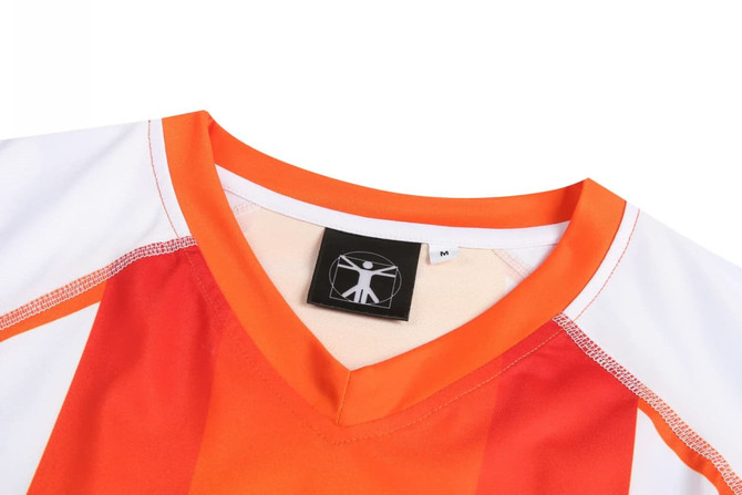 A sports uniform featuring vibrant orange and white colours with a V-neck design and a logo tag.