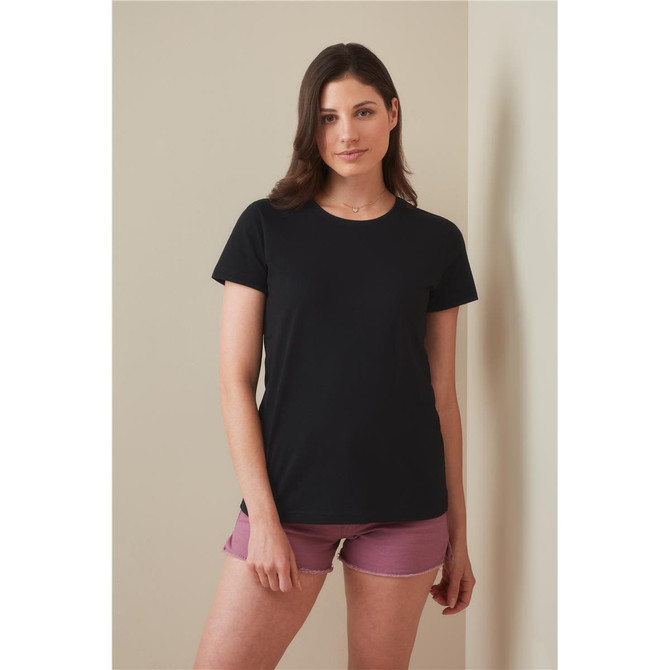 A black women's heavyweight comfort T-shirt displayed on a model, paired with pink shorts. The shirt has a simple design and a logo.