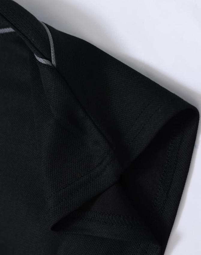 A close-up of a black polo shirt featuring short sleeves and a grey trim detail. The shirt has a logo.