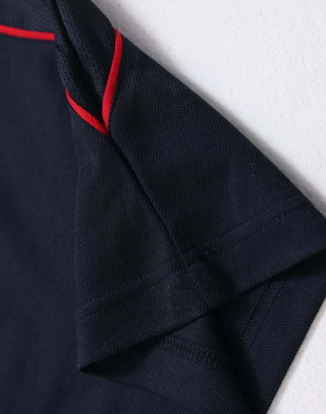 Men's short-sleeve polo shirt in navy blue with red accents. Features a logo on the collar.
