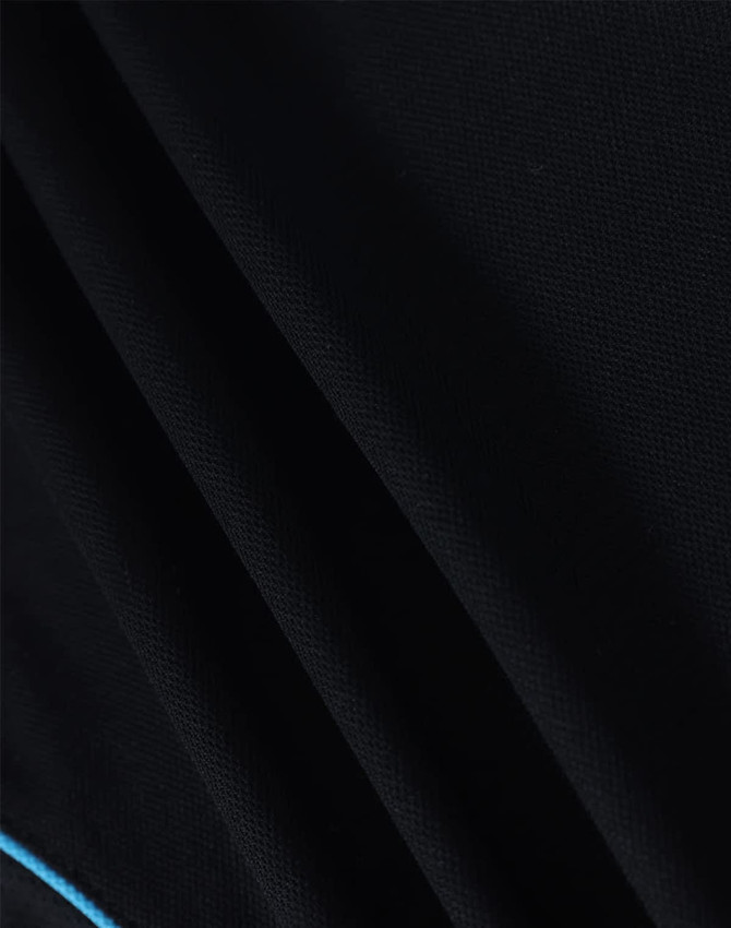 A close-up of a men's black polo shirt featuring a blue accent and a logo on the fabric.